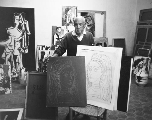 Picasso with
                    linocut plate and print, 1957
